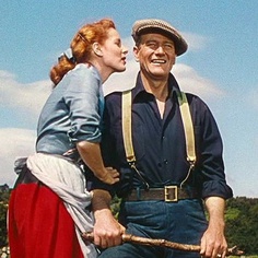Maureen O'Hara whispers a funny line into the Duke's ear to get a reaction, one that she's kept secret all these years 